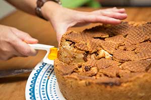 Aangesneden appeltaart met een dakje van stroopwafels